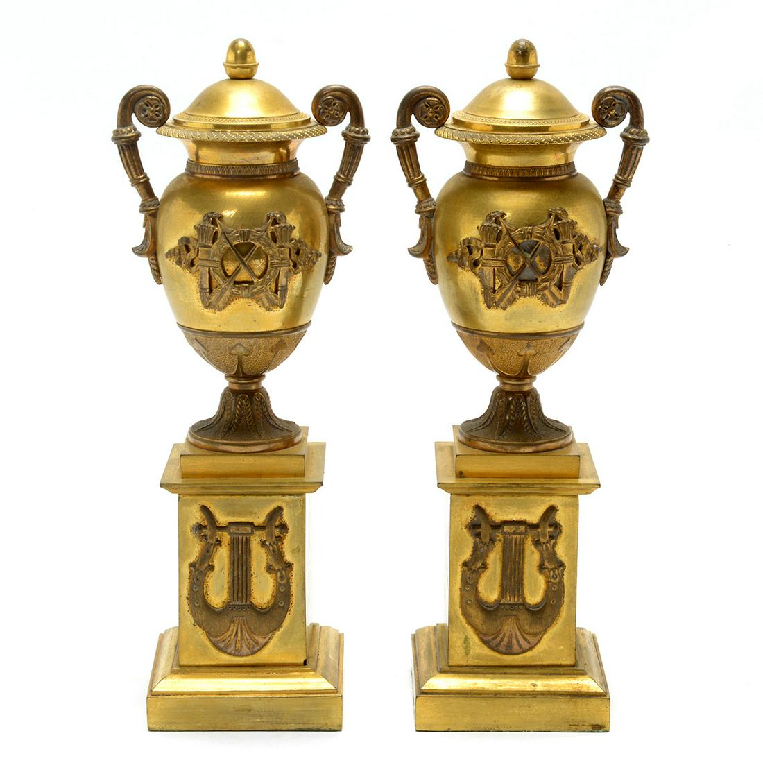 Charles X Neoclassical Gilded Bronze Urn Form Table: Charles X Neoclassical Gilded Bronze Urn Form Table Convertible Candlestick Garnitures. Lidded urn forms set on square pedestals, with the lids flipping to reveal candlesticks. Decorated with applied 