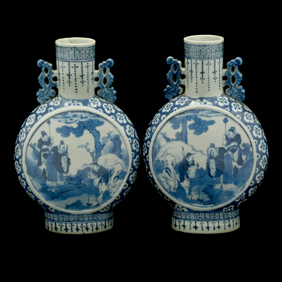 Two Blue and White 19th Century Moon Flasks: Two Blue and White 19th Century Moon Flasks. with two handles, painted landscape and figures. {Approximate height, 10 1/2 inches}. [Condition: Chips].