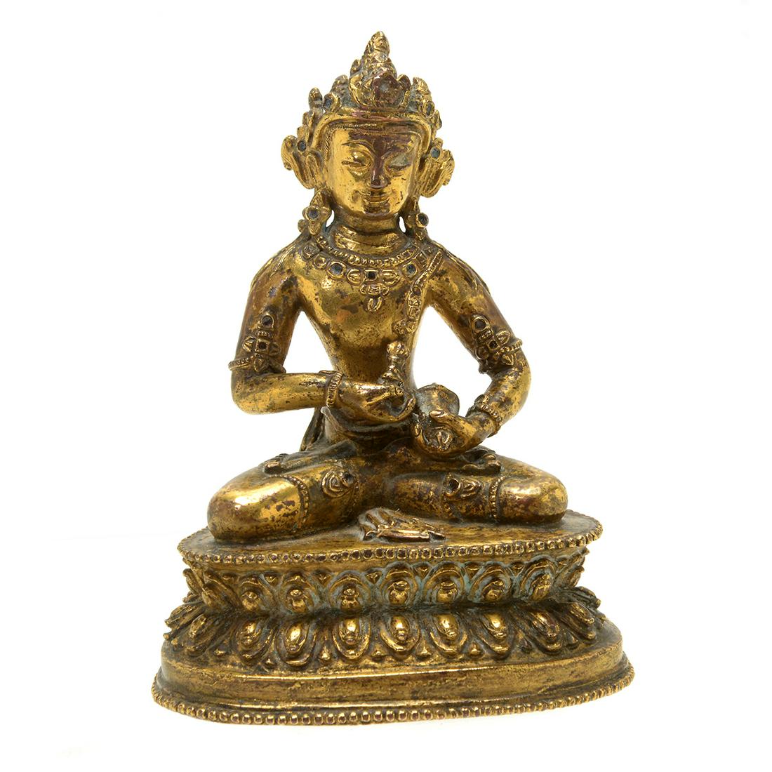 Sino - Tibetan Gilt Statue of Bodhisattva Vajrapani.: Sino - Tibetan Gilt Statue of Bodhisattva Vajrapani. Seated in padmasna on a double lotus base with beaded rims, holding the vajra in right hand and a bell in the left hand, wearing long beaded neckla