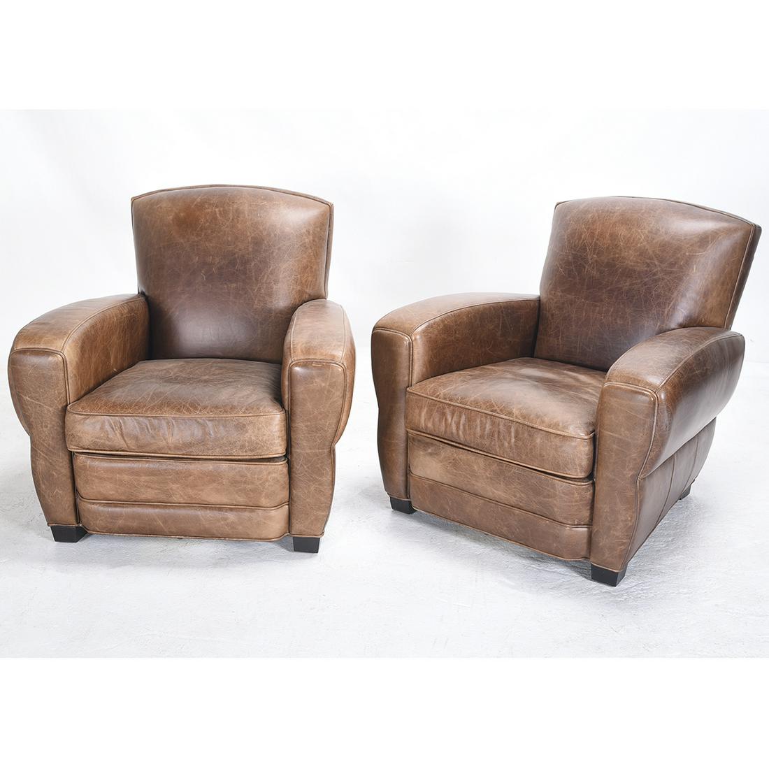 Pair of Art Deco Style Leather Club Chairs.: Pair of Art Deco Style Leather Club Chairs. Brown leather upholstery with riveting to the back, short ebonized feet. {Approximate dimensions: 32 1/2 high x 34 1/2 wide x 34 inches deep.}. Condition: S