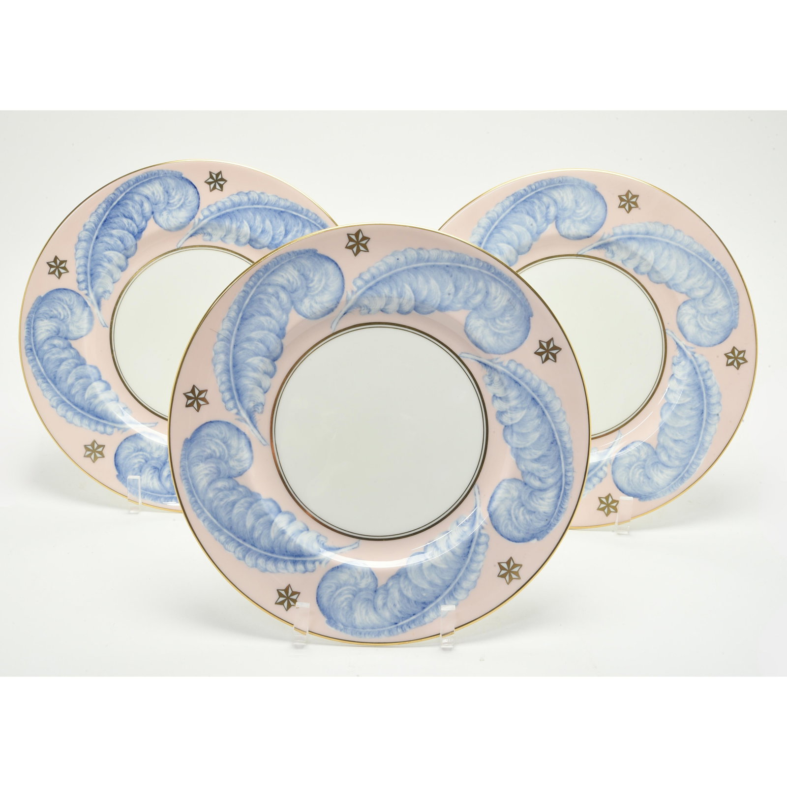 George Jones Twelve Porcelain Dinner Plates.: George Jones Twelve Porcelain Dinner Plates. Pink ground rims with billowy blue feathers and gilt stars. Black mark to the underside, 'Crescent & Sons mark, George Jones & Sons, Made in England, Bone 