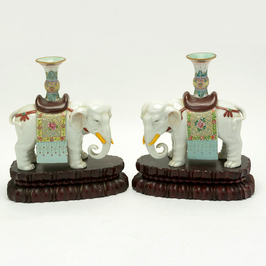 Pair of Chinese Famille Rose Porcelain Elephants: Pair of Chinese Famille Rose Porcelain Elephants Carrying Vases. Each standing four square, carrying vase atop, with carved rosewood stands. 20th Century. {Approximately 9 1/2 inches height without st