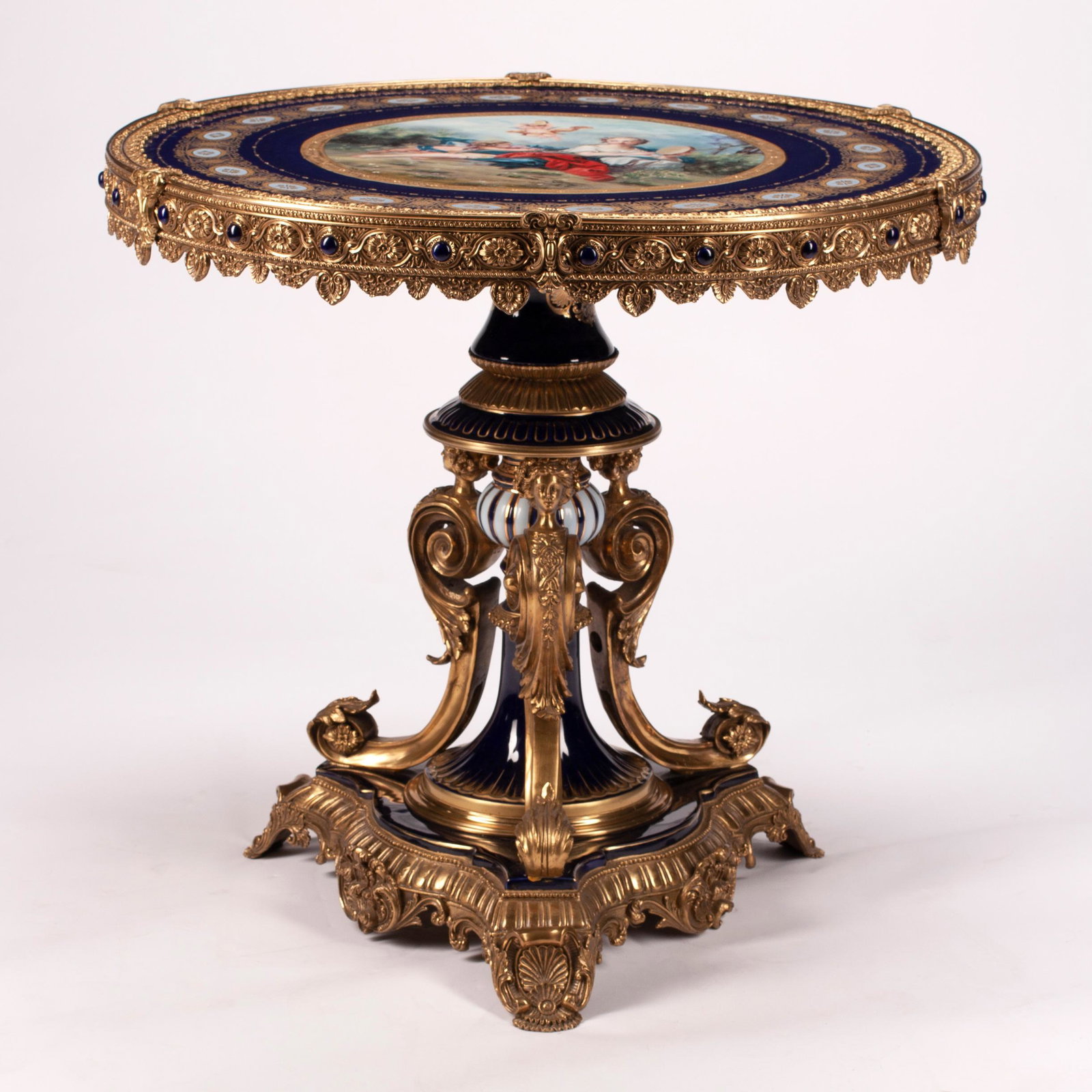 Louis XVI Style Round Porcelain Center Table with Gilt: Louis XVI Style Round Porcelain Center Table with Gilt Bronze Mounts. The table top inset with painted porcelain roundel of a young woman en pleine air with tamberine and putto, emblematic of the "Mus