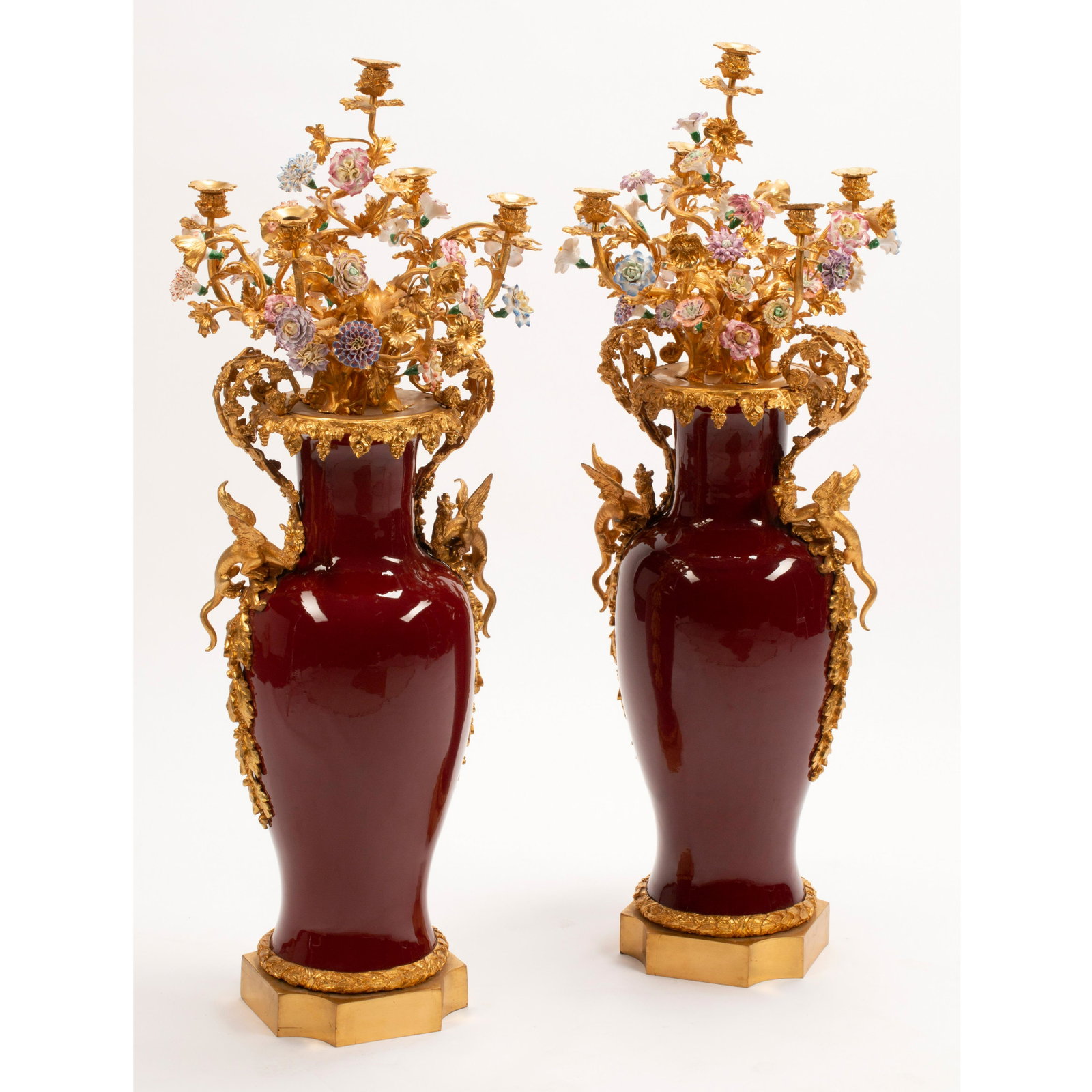 Pair of Louis XV Style Porcelain and Gilt Bronze: Pair of Louis XV Style Porcelain and Gilt Bronze Mounted Vases Issuing Candelabras. The pair of roleau vases in sang-de boeuf glaze, each decorated with gilt-bronze foliate double handles and dragons 