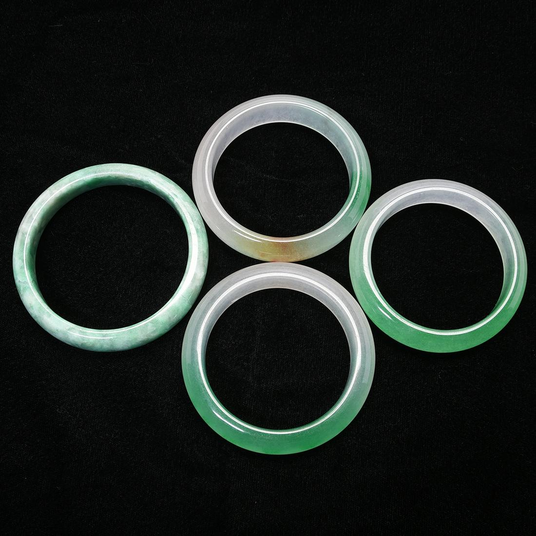 Group of Four Jadeite bangle Bracelets.: Group of Four Jadeite bangle Bracelets. Comprising four jade and jadeite bangle bracelet in various size and color. {Diameter of the largest: 3 inches}.
