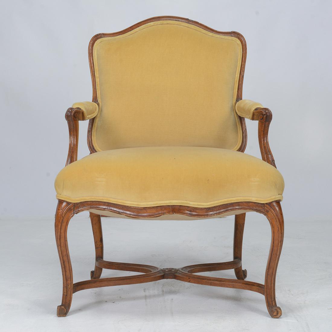 18th Century French Louis XV Fruitwood Bergere.: 18th Century French Louis XV Fruitwood Bergere. Arched back; scroll carved arms and feet; pale yellow velvet upholstery. {Approximate dimensions: 36 1/2 high x 27 1/2 wide x 26 inches deep.}. Conditio