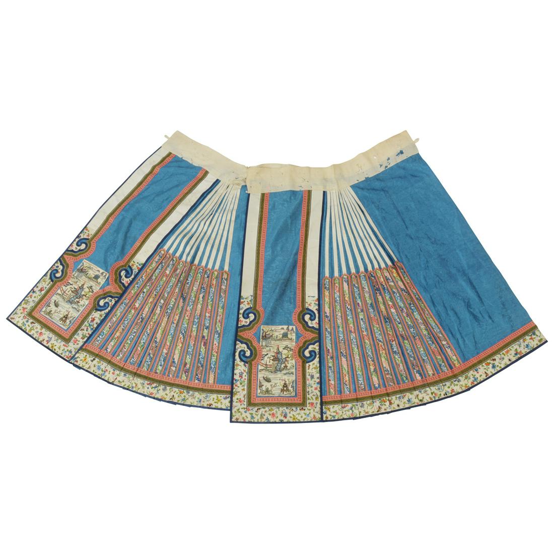 Chinese Blue-Ground Embroidered Skirt.: Chinese Blue-Ground Embroidered Skirt. The pleated bright blue ground decorated with the Eight Buddhist Emblems amidst swirling clouds, sewn with two white-ground embroidered landscape panels and flor