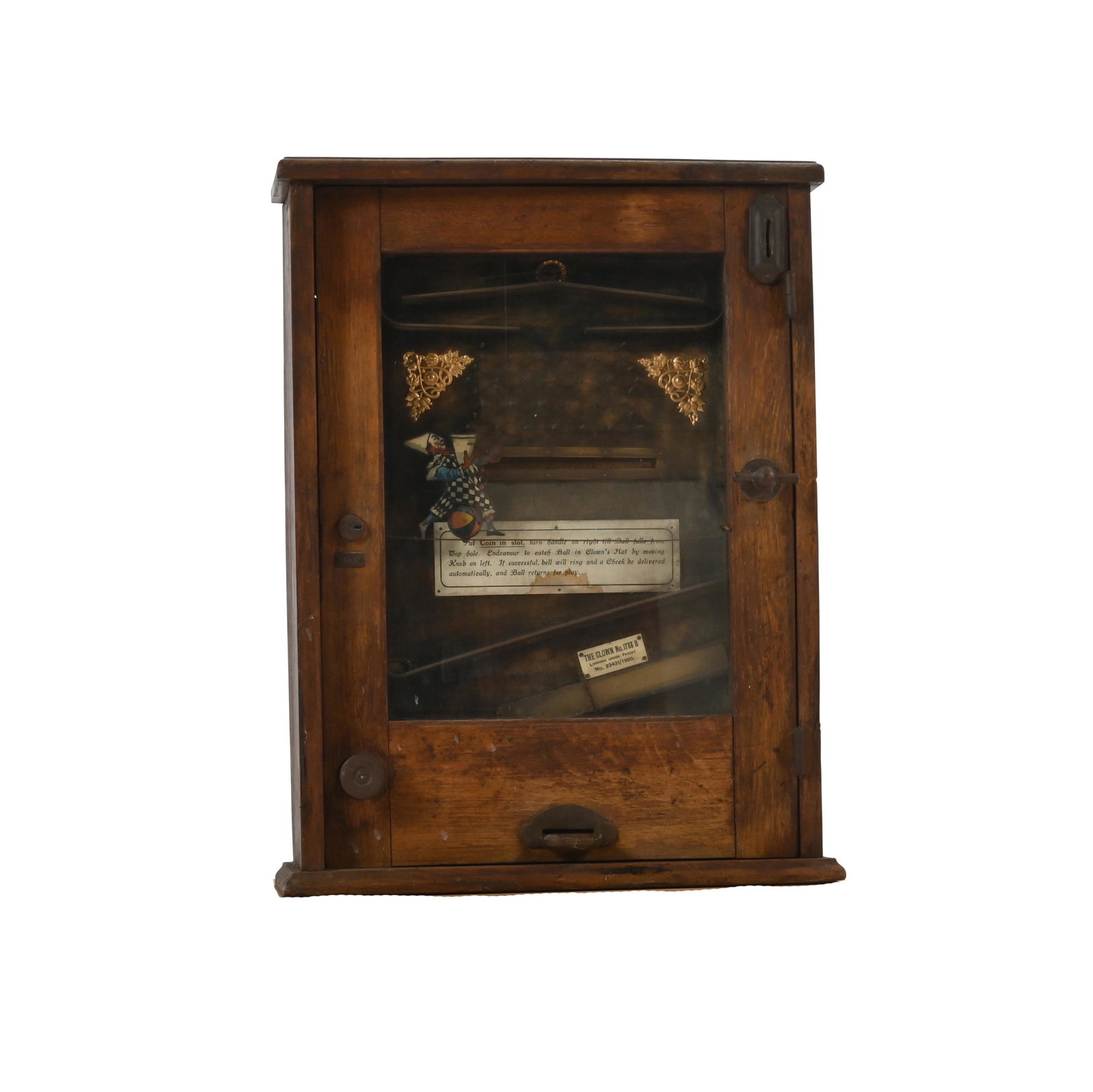 Clown Acrobat Arcade Machine, "The Clown No. 1788B".: Clown Acrobat Arcade Machine, "The Clown No. 1788B". Coin operated plinko style game in oak case. '17888' impressed to the side; 'THE CLOWN NO. 1788B . LICENSED UNDER PATENT NO. 23431/1900' to badge. 
