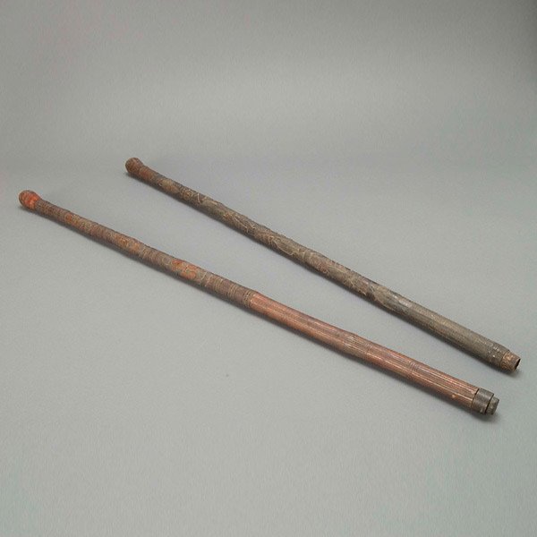 Two Japanese Carved Wood Canes, Meiji Period: Two Japanese Carved Wood Canes, Meiji Period. Both with rounded heads and very intricately carved designs, ornately patterned bands border various figural scenes. {Tallest 36 inches} [Natural age crac
