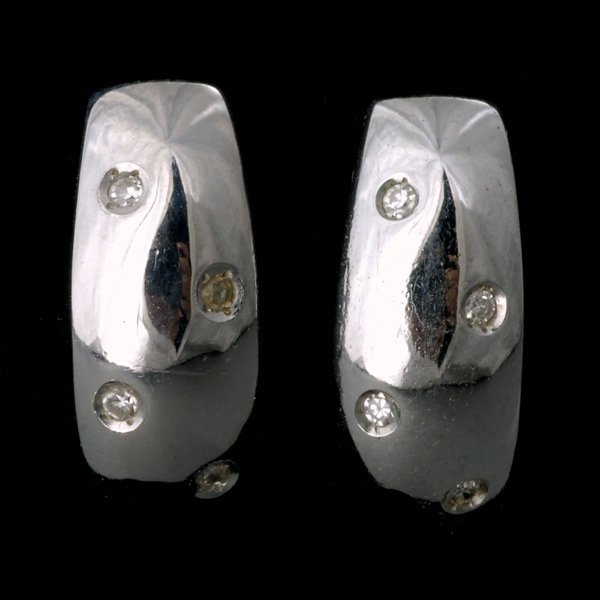 PAIR OF DIAMOND, 18K WHITE GOLD EARRINGS.: PAIR OF DIAMOND, 18K WHITE GOLD EARRINGS. Each features four full-cut diamonds weighing a total of approximately 0.05ct, flush set in an 18k white gold half-hoop style mounting, completed by a post an