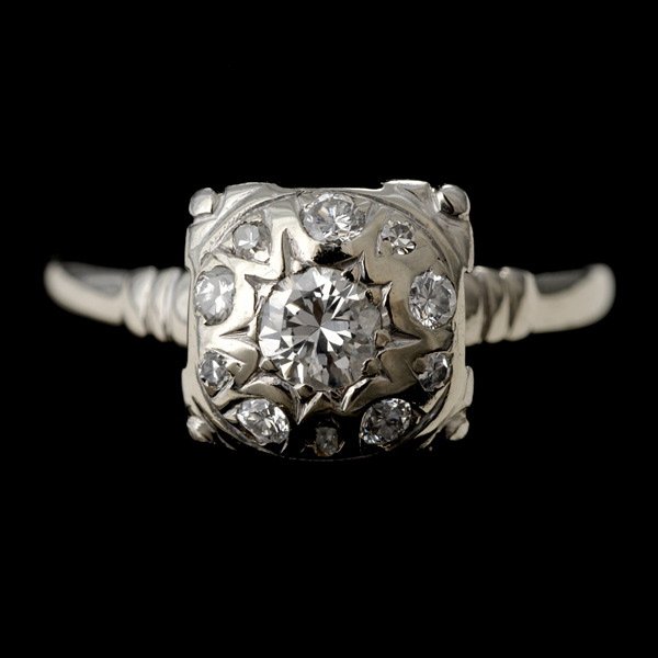 DIAMOND, 14K WHITE GOLD RING.: DIAMOND, 14K WHITE GOLD RING. Featuring eleven full-cut diamonds weighing a total of approximately 0.38ct, flush set in a 14k white gold mounting. 2.7 dwts. Size 7 3/4. Note: One diamond is broken.