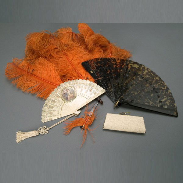 Three Vintage Fans and Small Clutch: Three Vintage Fans: the first of tortoise shell; the second with tortoise shell sticks and orange feathers; the third of ivory colored celluloid sticks with printed gilt border, featuring a center pai