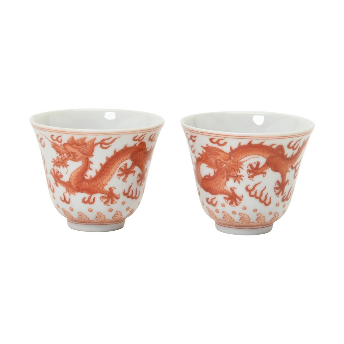 A Pair of Iron-Red 'Dragon' Wine Cups: A Pair of Iron-Red Dragon Wine Cups, Xianfeng Mark. Each cup elegantly potted with deep flaring sides, painted with two five-clawed dragons pursuing fiery pearls amidst flames above crashing waves, in