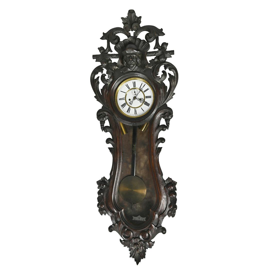 19th Century Continental Carved Walnut Wall Mounted: 19th Century Continental Carved Walnut Wall Mounted Regulator Clock. The crown with carved male bust in relief, large folitate carvings throughout. {Approximate dimensions: 49 high x 17 1/4 inches wid
