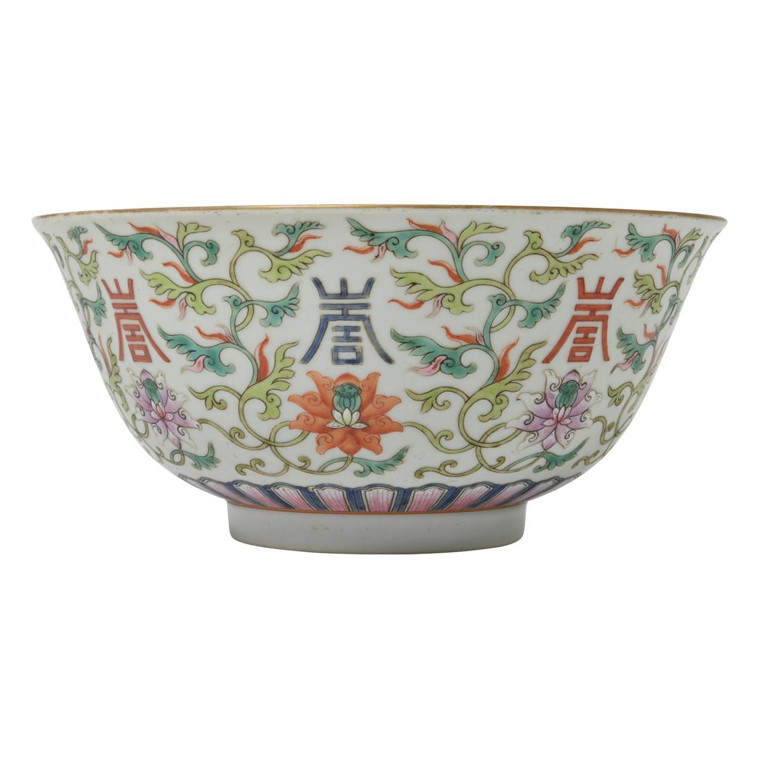 A Famille Rose Porcelain Lotus and 'Shou' Symbol Bowl.: A Famille Rose Porcelain Lotus and 'Shou' Symbol Bowl. The bowl with an everted gilt rim, decorated with stylized lotus and 'Shou' symbol patterns, with a lappet band on foot, the interior depicting f