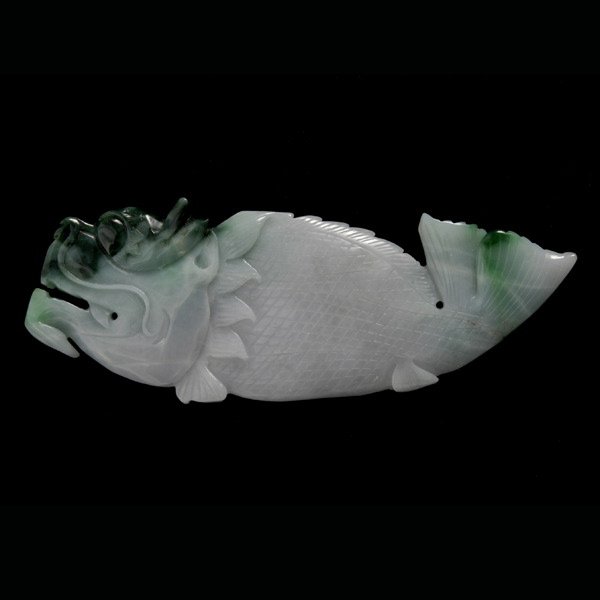 CARVED JADE FISH.: CARVED JADE FISH. Designed as a mythical dragon fish, carved from a 140.00mm x 50.00mm x 8.00mm jadeite plaque.