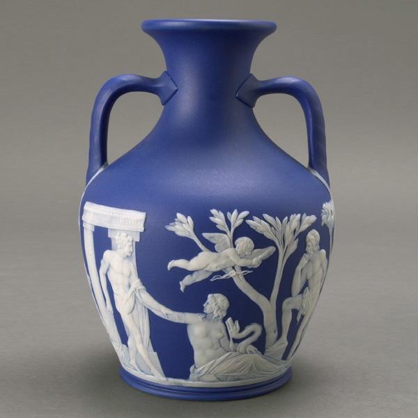 Wedgwood Jasperware Two Handled Portland Vase: Wedgwood Portland Dark Blue Jasperware Two Handled Vase, 19th Century, the urn form with twin bearded man masks, impressed on base two dots/"Wedgwood/V." {Height 8 inches} [Good condition]