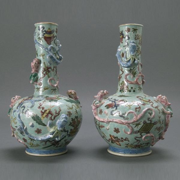 Two Molded Famille Rose Enameled Porcelain Vases: A Pair of Molded Famille Rose Enameled Porcelain Vases, of subtle hues with gilt rims; Buddhist symbols, flowers and ribbon designs throughout, pink and blue dragons encircle the body and neck, bearin