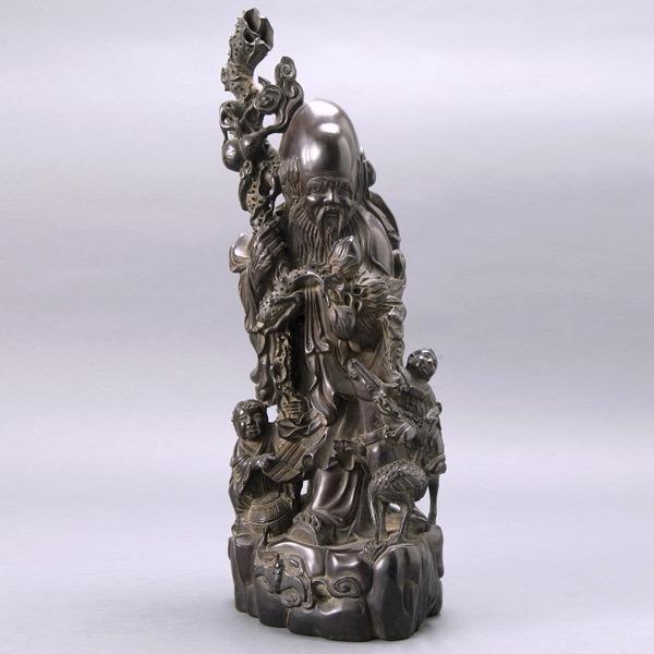 A Carved Wood Figure of Shao Xin: A Carved Wood Figure of Shao Xin, depicts Shao Xin holding a staff in one hand and a peach branch in the other, two boys, a deer and a crane stand at his side {Height 19 inches}