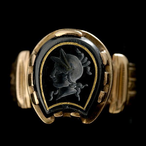 VICTORIAN HEMATITE INTAGLIO, 14K YELLOW GOLD RING: VICTORIAN HEMATITE INTAGLIO, 14K YELLOW GOLD RING. Featuring one shield shaped hematite intaglio, depicting a warrior, with an inlaid gold frame, prong set in a 14k yellow gold mounting. 3.8 dwts. Siz