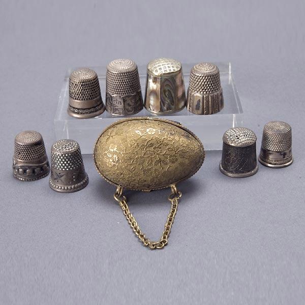 Seven Assorted Silver Thimbles & Case: Seven Assorted Silver Thimbles, a Mother of Pearl Thimble and a Gilt Brass Egg Form Thimble Case (9) {Height of case 1 1/2 inches}