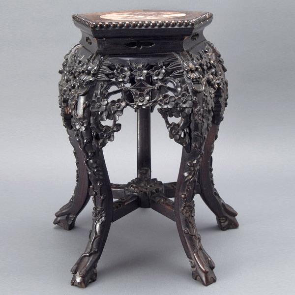 A Chinese Export Rosewood Display Stand: A Chinese Export Rosewood Display Stand, with a pentagonal seat inlaid with a circular marble panel, carved in openwork with elaborate blossoming prunus trees and dragon masks to each leg {Height 19 1