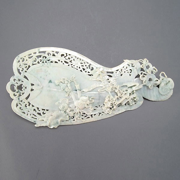 A Carved Jadeite Fan with Openwork Detail: A Carved Jadeite Fan with Openwork Detail, of light celadon green with deep green inclusions, decorated in relief with auspicious symbols, double gourds, flowers, bats and coins, the traditional fan f