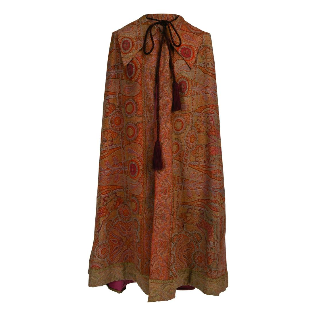 Lady's 1860s Kashmir Cape with Silk Lining.: Lady's 1860s Kashmir Cape with Silk Lining. Deep tri pointed collar, the magenta lining with single pocket. This item is sold with additional scraps of the original rectangular shawl. Provenance: Sale