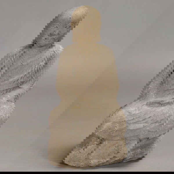 A Gray Stone Seated Lohan: A Gray Stone Seated Lohan, with kind and gentle facial features, hands resting in his lap while sitting upon a degraded rectangular base {Height 28 inches} [Wear, chips, losses]