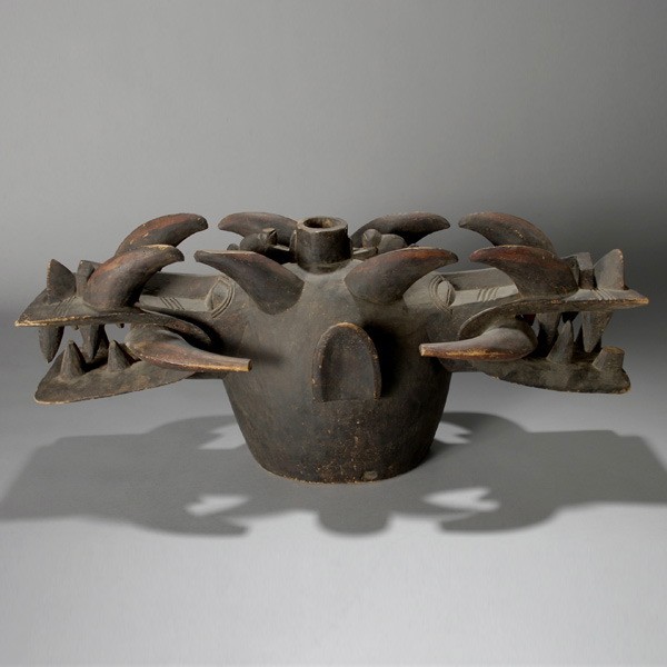 African helmet mask ex Emerson Woelffer: SENUFO "Fire Spiter" Janus-head helmet mask. Blackened wood. H = 30 inches. Provenance: the estate of Emerson Woelffer, Los Angeles.