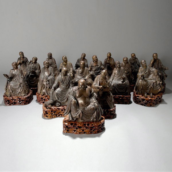 A Set of Eighteen Bronze Luohan: A Set of Eighteen Bronze Luohan, Each of the Buddhist disciples is depicted seated in a unique pose beneath long patterned robes and smooth bald heads, objects including animals, vessels and other att