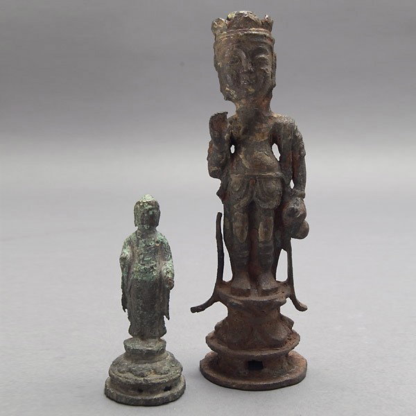 A Korean Iron Avalokiteshvara & a Bronze Buddha: A Korean Iron Statue of a Standing Avalokiteshvara and a Small Bronze Standing Buddha, The first stands upon a tiered base with the left hand holding a vessel while the right hand is held up towards t