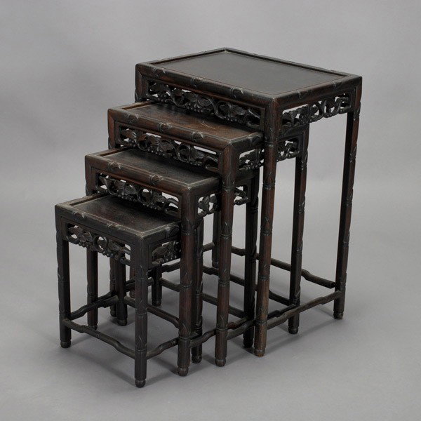 A Set of Four Carved Wood Nesting Side Tables: A Set of Four Carved Wood Nesting Side Tables, each with bamboo form legs and borders above leafy grapevine aprons, the four legs supported by stepped stretchers {Largest Dimensions 28 x 20 14 1/2 inc
