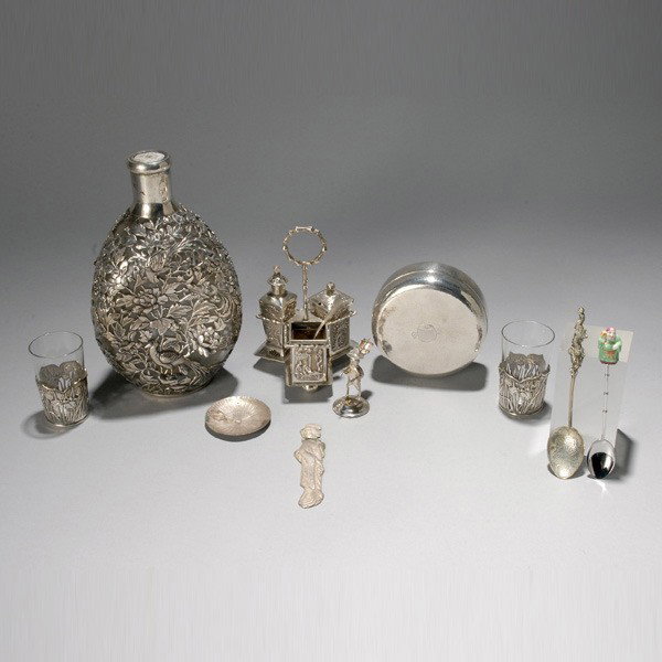 Asian Silver Group: nine assorted items: Asian Silver Group: a Luenwo Condiment Set; two Arthur Bond sake cups with iris chased mounts; a Yuchang silver overlay decanter; two souvenir spoons; and a figural miniature (losses) (9) {Height of d