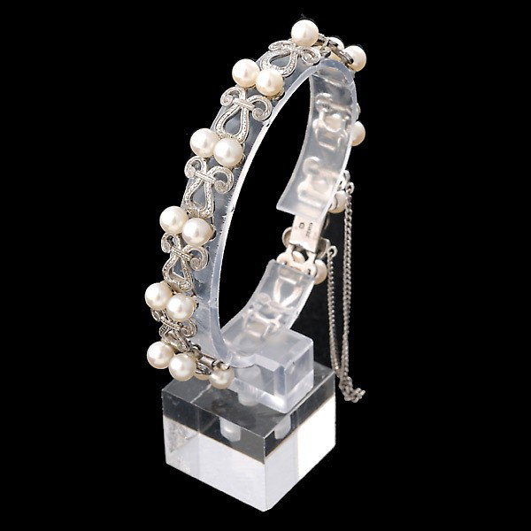MIKIMOTO CULTURED PEARL, SILVER BRACELET.: MIKIMOTO CULTURED PEARL, SILVER BRACELET. Featuring twenty-five cultured pearls measuring approximately 4.00 mm, post set in an engraved scroll motif articulated mounting completed by a box clasp with