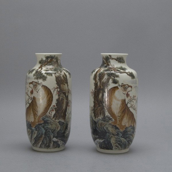 A Pair of Polychrome Enameled Porcelain Vases: A Pair of Polychrome Enameled Porcelain Vases, decorated with tigers roaring while standing upon rocks beneath a large pine tree, an inscription verso, a mark to each base {Height 9 1/2 inches} [Surfa