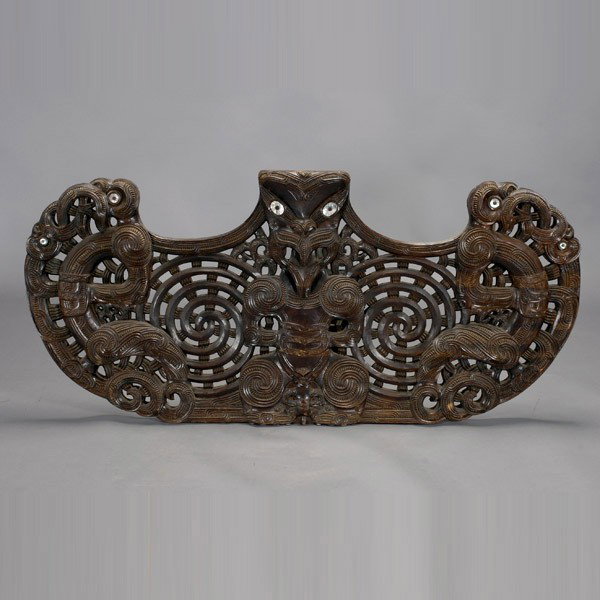 Maori architectural element: MAORI architectural ornament. Large openwork carving, wood stained dark red brown, mother-of-pearl eyes. Width 66 inches. In very good condition.