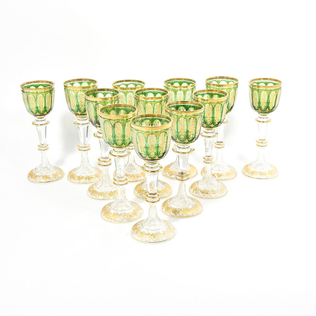 Twelve Continental Green and Gold Wine Stems.: Twelve Continental Green and Gold Wine Stems. Attributed to Moser. The panelled bowls under gilt rims; engraved with floral bands to panels over scallop band to lower bowl; on clear, panelled stems, w