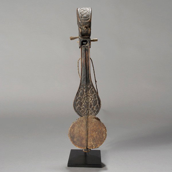 nepalese stringed instrument: NEPALESE stringed instrument. Carved wood with hide and strings. Height 21 inches. IN good condition, rubbed and polished from extensive use.