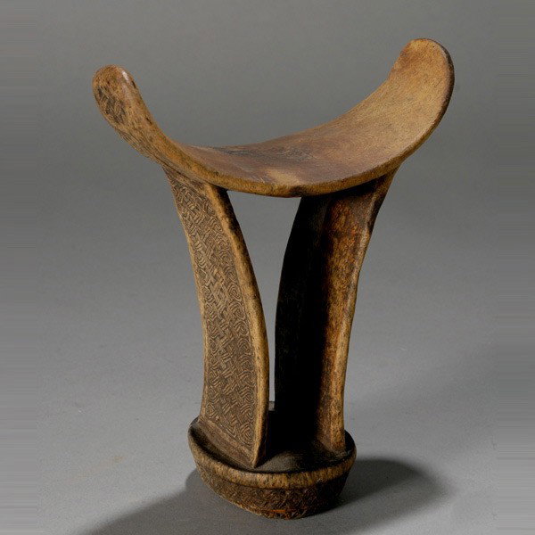boni (Somalia) headrest (barkin): BONI (Somalia) headrest (barkin). Wood, incised on the sides with intricate weave design, a star on the cradle. Shows signs of extensive use. Height 7 inches.