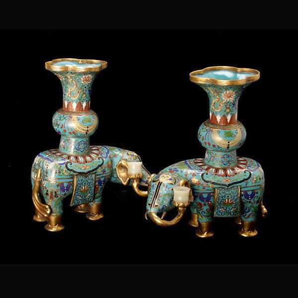 A Pair of Cloisonné-Enameled Elephants and Vases: A Pair of Cloisonné-Enameled Elephants and Vases, shown standing below lobe-rimed vases displaying flowers, dragons and butterflies to a turquoise ground, with gilt feet, ears and trunks holding smal