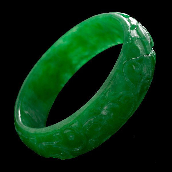 JADE BRACELET.: JADE BRACELET. The carved jadeite bangle measures 20.00 mm in width and 60.00 mm in internal diameter.