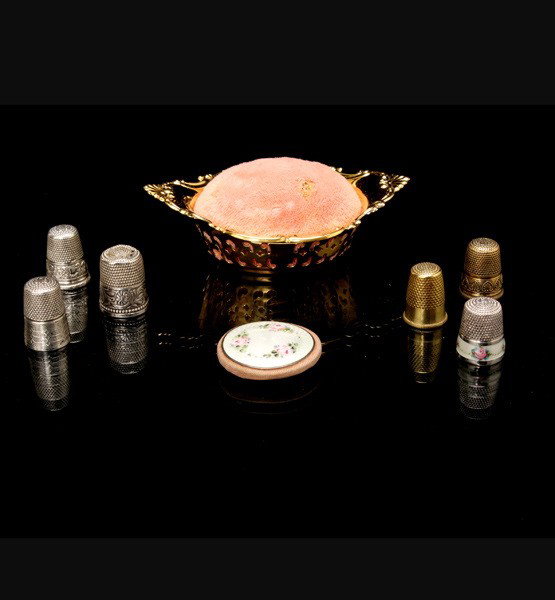 Collection of Sewing Items: Collection of Sewing Items: a Gorham sterling pin cushion; an enamel thumb guard; and six thimbles (two stamped sterling) {Length of pin cushion 3 3/4 inches}