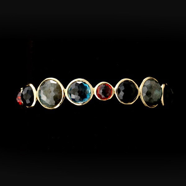 GARNET, LABRADORITE, ONYX,TOPAZ, 18K Y/G BRACELET: IPPOLITA GARNET, LABRADORITE, BLACK ONYX, BLUE TOPAZ, 18K YELLOW GOLD BRACELET. Composed of four labradorite, four black onyx, four garnet and three blue topaz faceted topped round cabochons, each bez