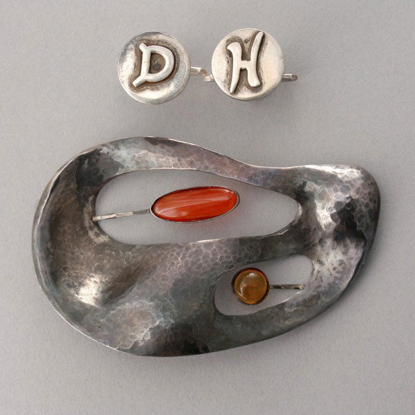 COLLECTION OF TWO SILVER ITEMS.: COLLECTION OF TWO SILVER ITEMS. Including a hammered silver, abstract pendant and a pair of sterling silver cufflinks signed LaCucarracha. Provenance: the estate of Douglas Hague & Jorge Euan, San Fra