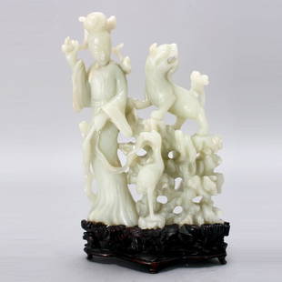 A Fine Jade Carving of a Female Immortal & Animal: A Fine Jade Carving of a Female Immortal and Animals, The elegant robed figure shown standing while holding a leafy lingzhi branch and a fly whisk, a fu lion and a majestic crane proudly stand beside