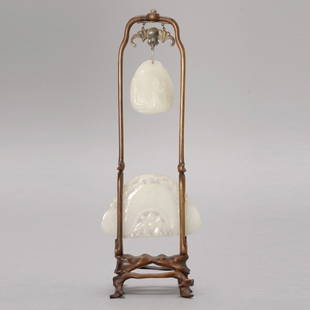 Two White Jade Carvings Mounted with a Wood Stand: Two White Jade Carvings Mounted with a Wood Stand, The first a chime form pendant carved with 'lingjiao' (horned water chestnut) and a lotus blossom below; the second a polished pebble hanging above