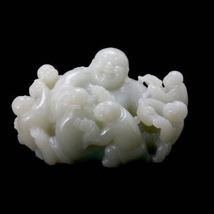 A Pale Green Jade Carving of Budhai and Children: A Pale Greenish-White Jade Carving of Budhai and Children, The central reclining figure shown smiling while holding a sphere in one hand, his rounded body engulfed by five small boys accompanied by