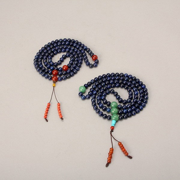 Two Lapis Lazuli Necklaces: Two Lapis Lazuli Necklaces, Each strung with 108 lapis lazuli beads interspaced between four green-stone or red-glass beads, both finished with tassels of small red beads. Length of Each: 27 1/2 inche