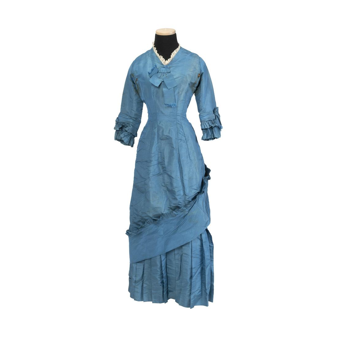 1870s Lady's Turquoise Silk Dinner Dress.: 1870s Lady's Turquoise Silk Dinner Dress. Stitched in short lace collar, over long fitted princess line dress, with three-quarter length sleeves, and applied ruffles and gathers to sleeve hems, hip an